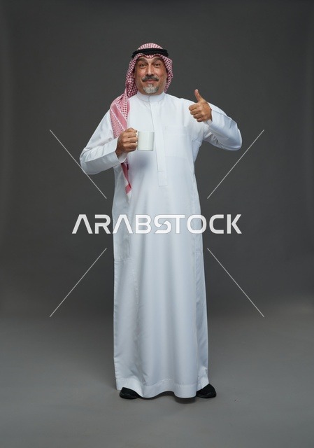 رجل سعودي مسن يحمل كوب قهوة وعلامة موافقة