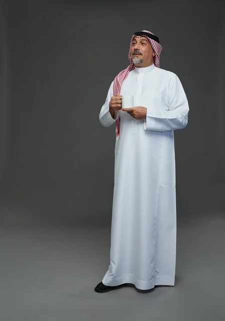 Saudi Elderly Man in Traditional Dress with Coffee Mug