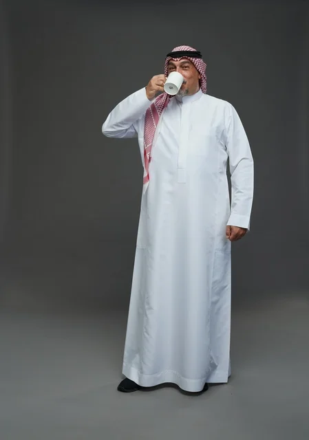 Elderly Saudi Man Drinking Coffee in Traditional Attire