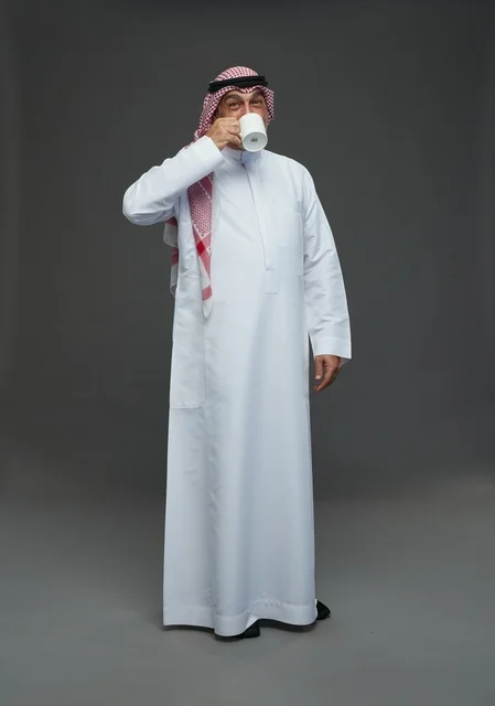 Elderly Saudi Man Drinking Coffee in Traditional Thobe