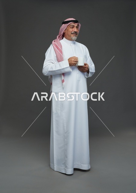 رجل سعودي مسن يحمل كوب قهوة أبيض