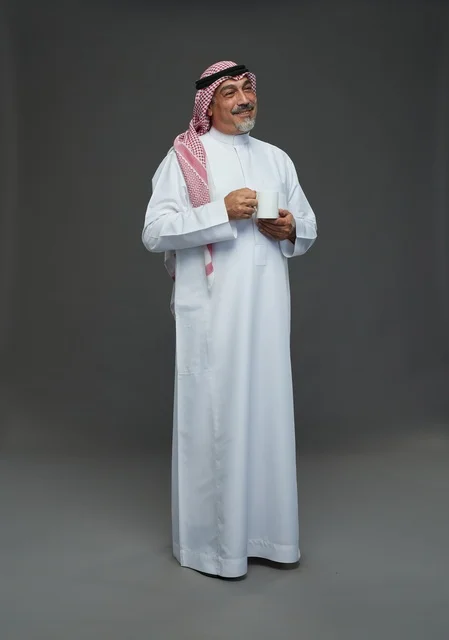Elderly Saudi Man Holding White Coffee Mug in Studio