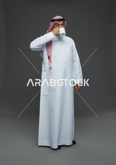 رجل سعودي مسن بالزي التقليدي يشرب من كوب قهوة