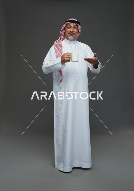 رجل سعودي مسن يحمل كوب قهوة أبيض