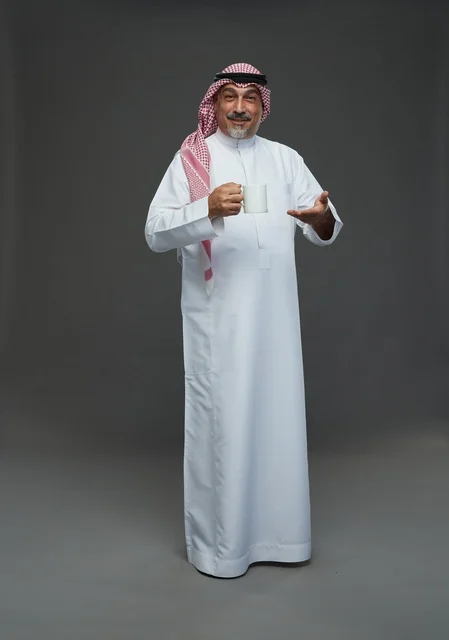 Elderly Saudi Man Holding Coffee Mug in Studio