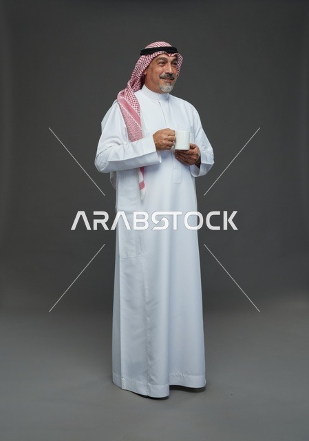Elderly Saudi Man Holding White Coffee Mug in Studio