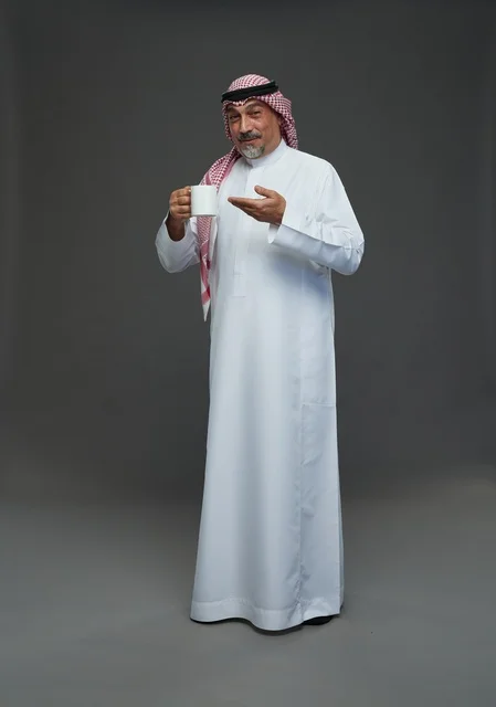 Elderly Saudi Man Holding White Coffee Mug in Studio