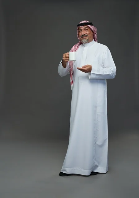 Senior Saudi Man in Traditional Thobe Holding White Mug