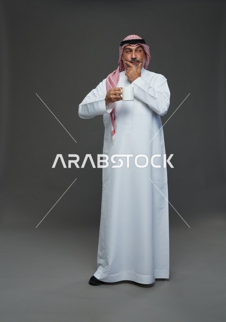 Elderly Saudi Man in Thobe Holding White Coffee Mug