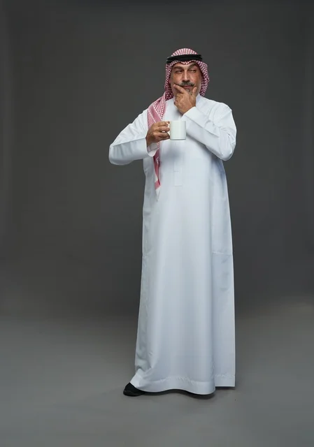 Elderly Saudi Man in Thobe Holding White Coffee Mug