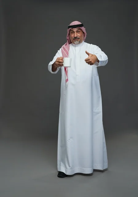 Elderly Saudi Man Holding White Mug Thumbs Up