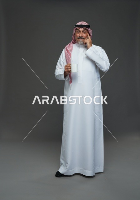 Elderly Saudi man holding a white coffee mug