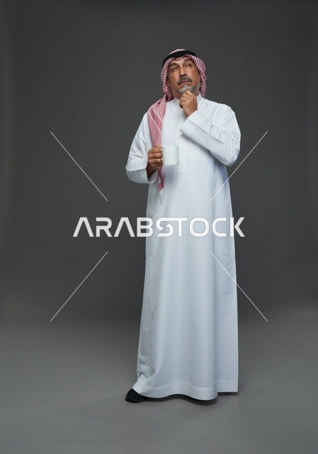 Elderly Saudi man holding a white coffee mug