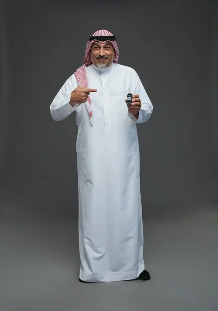 Saudi man holding a car key with a smile