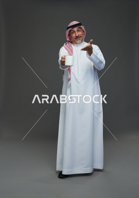 Elderly Saudi man holding a white coffee mug