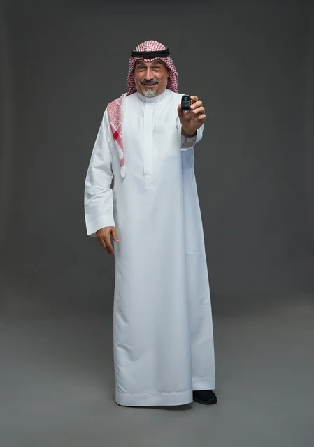 Saudi Man Holding Car Key on Gray Background