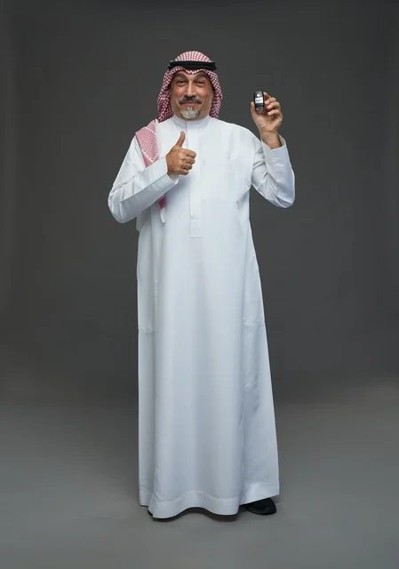 Saudi Man Holding Car Key with Thumbs Up Gesture