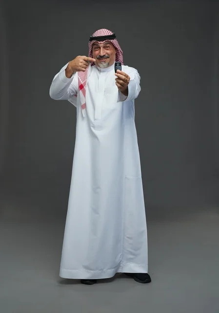 رجل سعودي بالثوب التقليدي يحمل مفتاح سيارة
