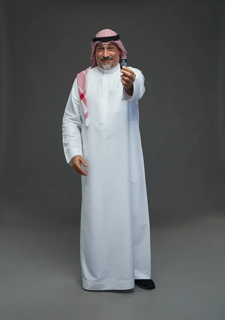 Saudi Man Holding Car Key on Gray Background