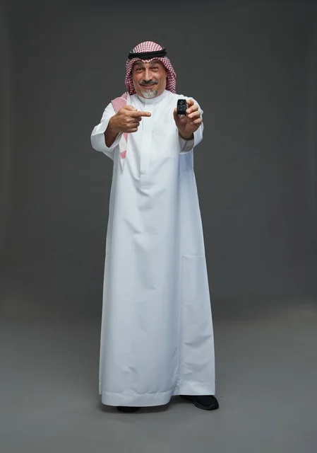 Saudi man holding a car key with a smile
