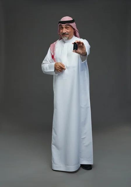 Saudi Man Holding Car Key on Grey Background