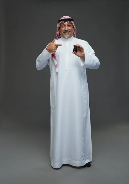 Saudi Man Holding Car Key on Grey Background