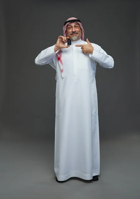 رجل سعودي يحمل مفتاح سيارة في الاستوديو