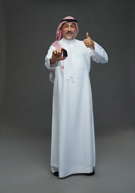 Saudi man holding a car key with a smile