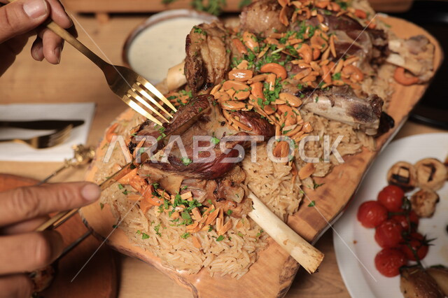 طبق اللحم والارز المزين بالمكسرات ، تناول طعام الغداء ، وجبة غذائية ، الافطار الرمضاني ، ماكولات عربية 