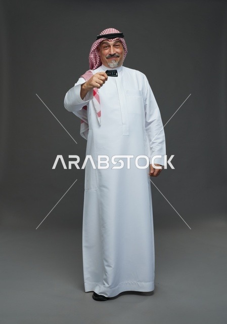 رجل سعودي بالثوب التقليدي يحمل مفتاح سيارة