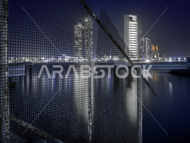 إطلالة ليلية رائعة لكورنيش أبو ظبي ، إنعكاس َأضواء الأبراج الشاهقة و ناطحات السحاب على مياه الخليج ، واجهة بحرية ساحرة ، الإمارات العربية المتحدة