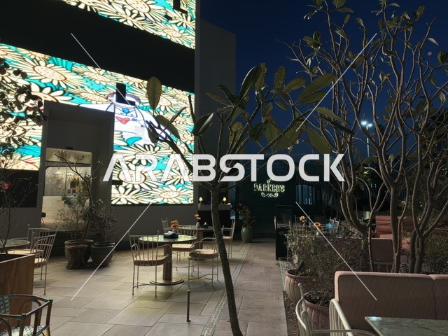 جلسات مطعم خارجية مع شاشات رقمية مضيئة ليلاً