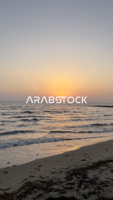 غروب الشمس فوق أفق البحر على الشاطئ الرملي وقت الغروب