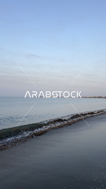 Small Ocean Waves on Dark Sandy Beach During Sunrise