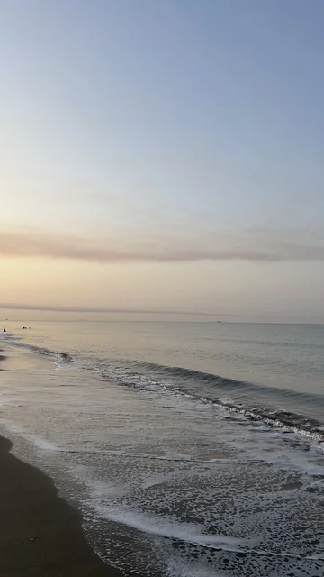 Calm Ocean Waves on Dark Sand Beach at Sunrise
