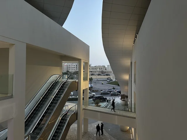 Modern Building Interior with Escalators and Walkway