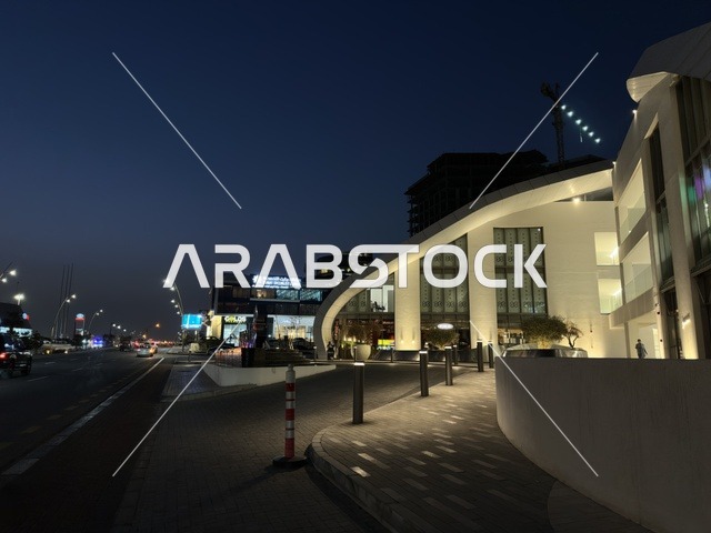 مبنى أبيض حديث في شارع بالمدينة ليلاً