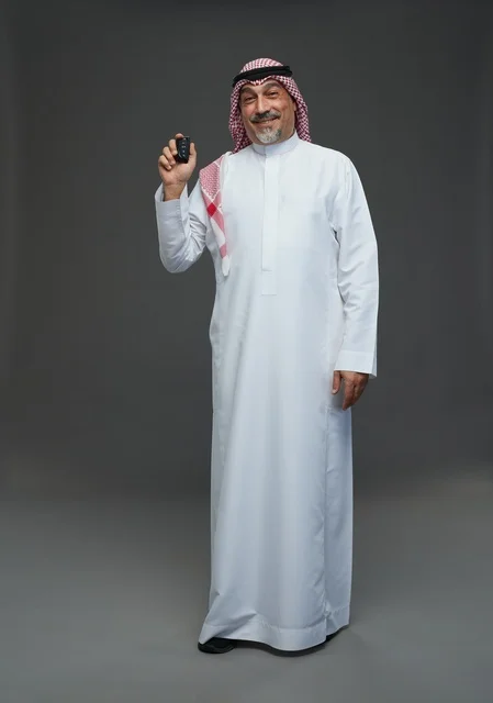 رجل سعودي يحمل مفتاح سيارة ريموت في الاستوديو