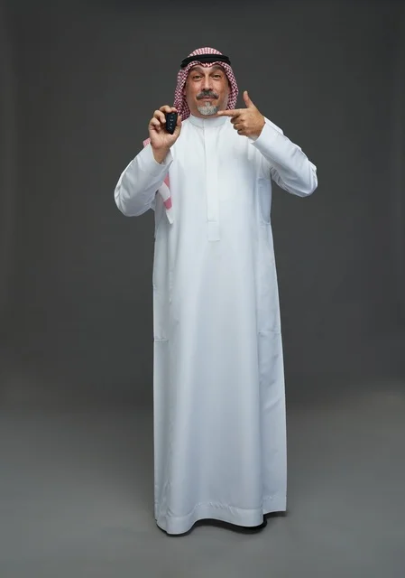 Middle Eastern Man Holding Car Key on Grey Background