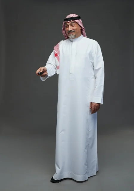 Saudi Man in Traditional Thobe Holding Remote Control