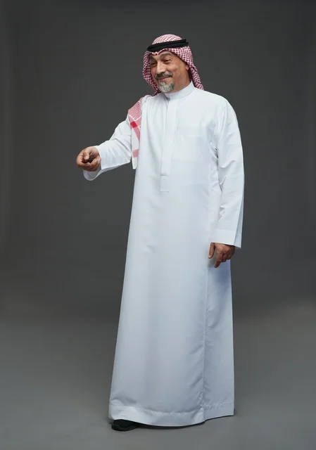 رجل سعودي بالثوب التقليدي يمسك بجهاز تحكم