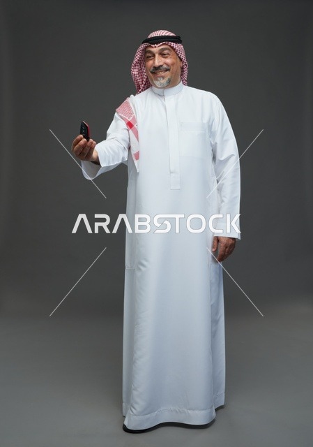 رجل سعودي يحمل مفتاح سيارة في الاستوديو