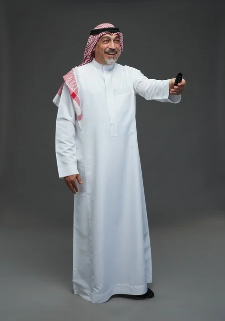 Senior Arab Man Holding Car Key Remote on Grey Background