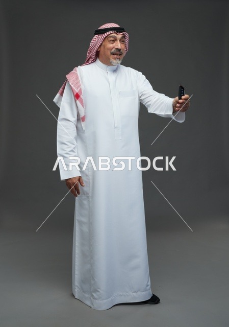 رجل سعودي يحمل ريموت سيارة في الاستوديو