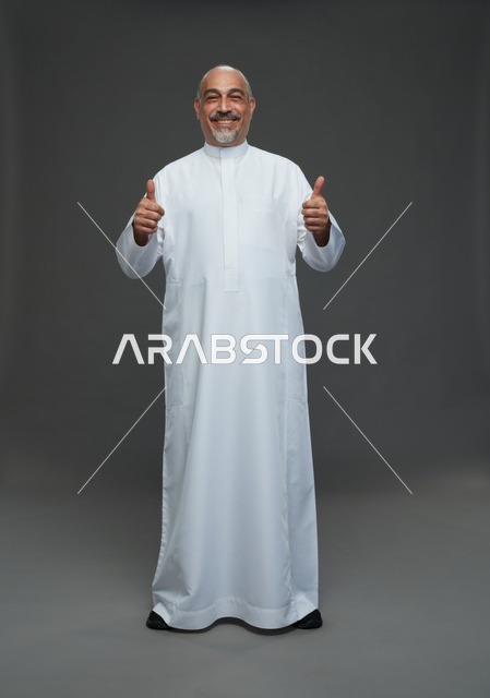 رجل سعودي مبتسم يشير بعلامة الإعجاب في الاستوديو