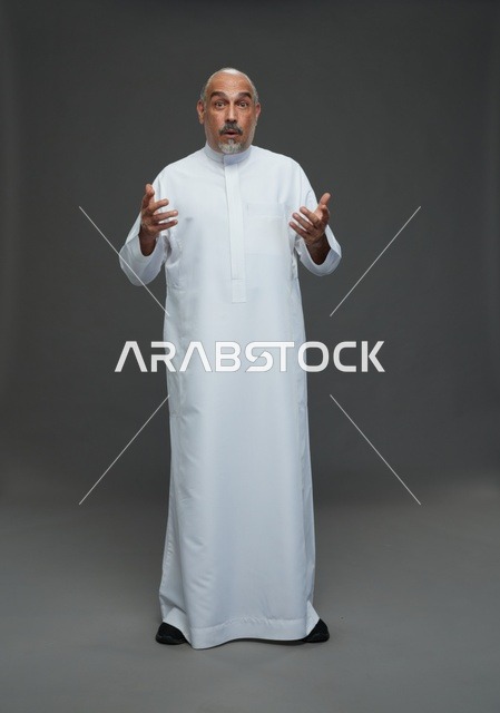 رجل عربي متفاجئ يرتدي الثوب الأبيض في الاستوديو