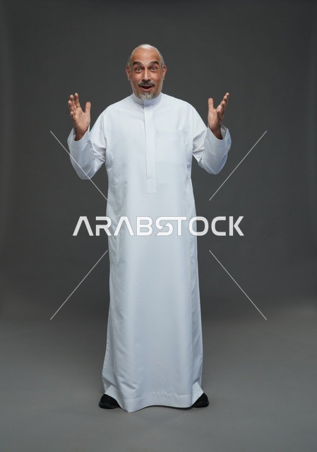 رجل سعودي مسن مندهش بالثوب الأبيض في استوديو