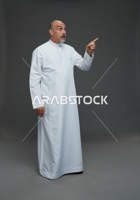 رجل عربي مندهش بالثوب الأبيض يشير للأعلى