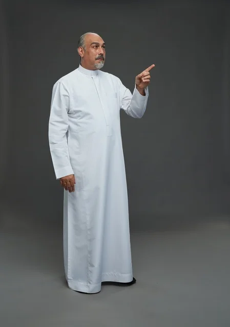 Arab Man in White Thobe Pointing on Gray Background Arab Man in White Thobe Pointing on Gray Background