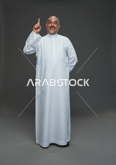 Smiling Arab Man in White Thobe Pointing Up